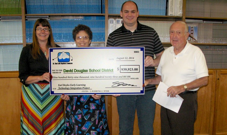 Picture of 4 people with large check FROM LEFT: JULIE S. OMELCHUCK, MHCRC, FRIEDA CHRISTOPHER, SCHOOL BOARD CHAIR, KYLE RIGGS, VICE CHAIR, RICH GOHEEN, MHCRC FAIRVIEW REPRESENTATIVE. DAVID DOUGLAS SCHOOL BOARD MEETING, AUGUST 14, 2014.